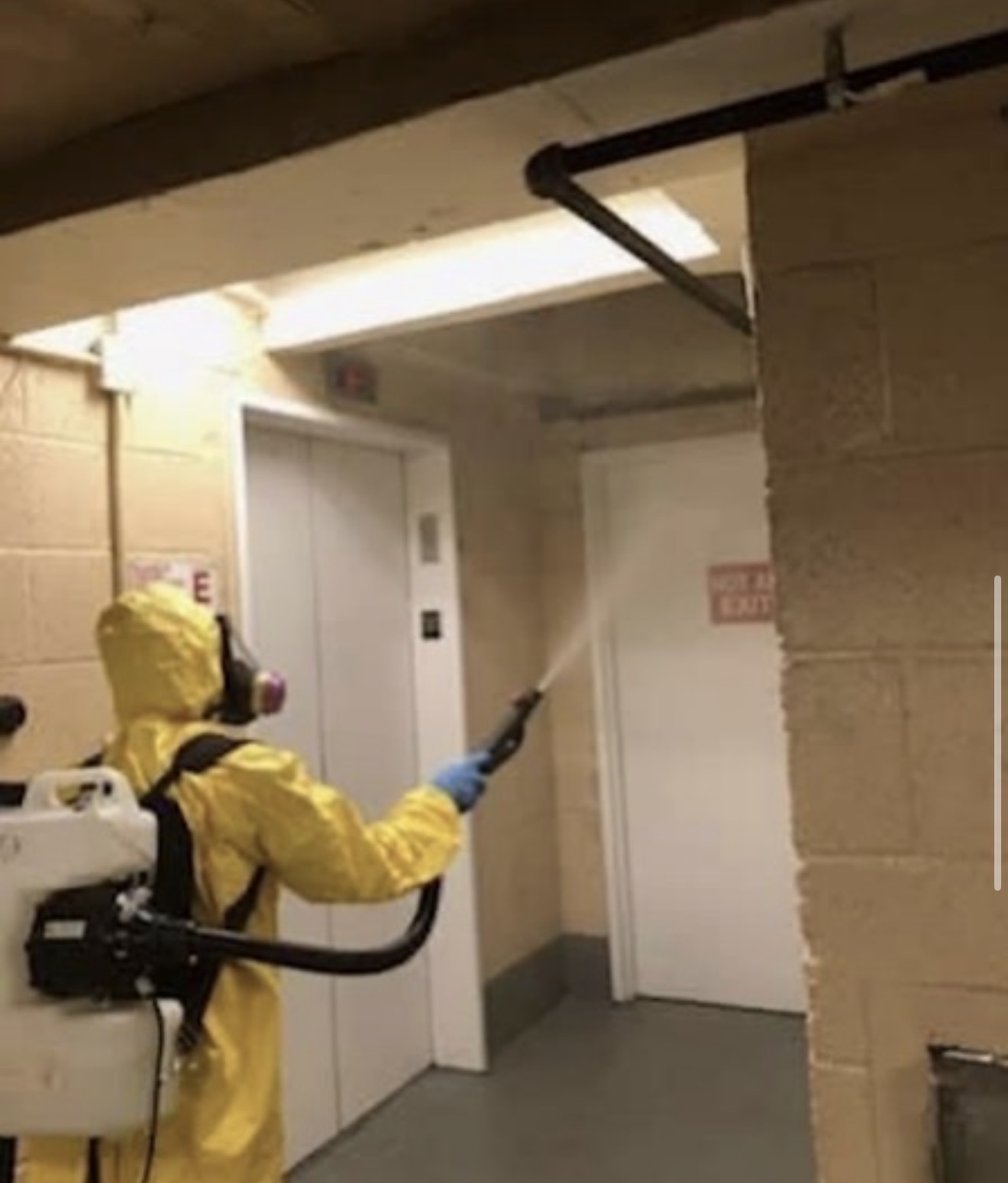 Operator fogging a building hallway to neutralize stubborn smoke and biological odors.
